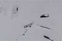 The rotor hits the snow, the helicopter crashes and rolls down the slope